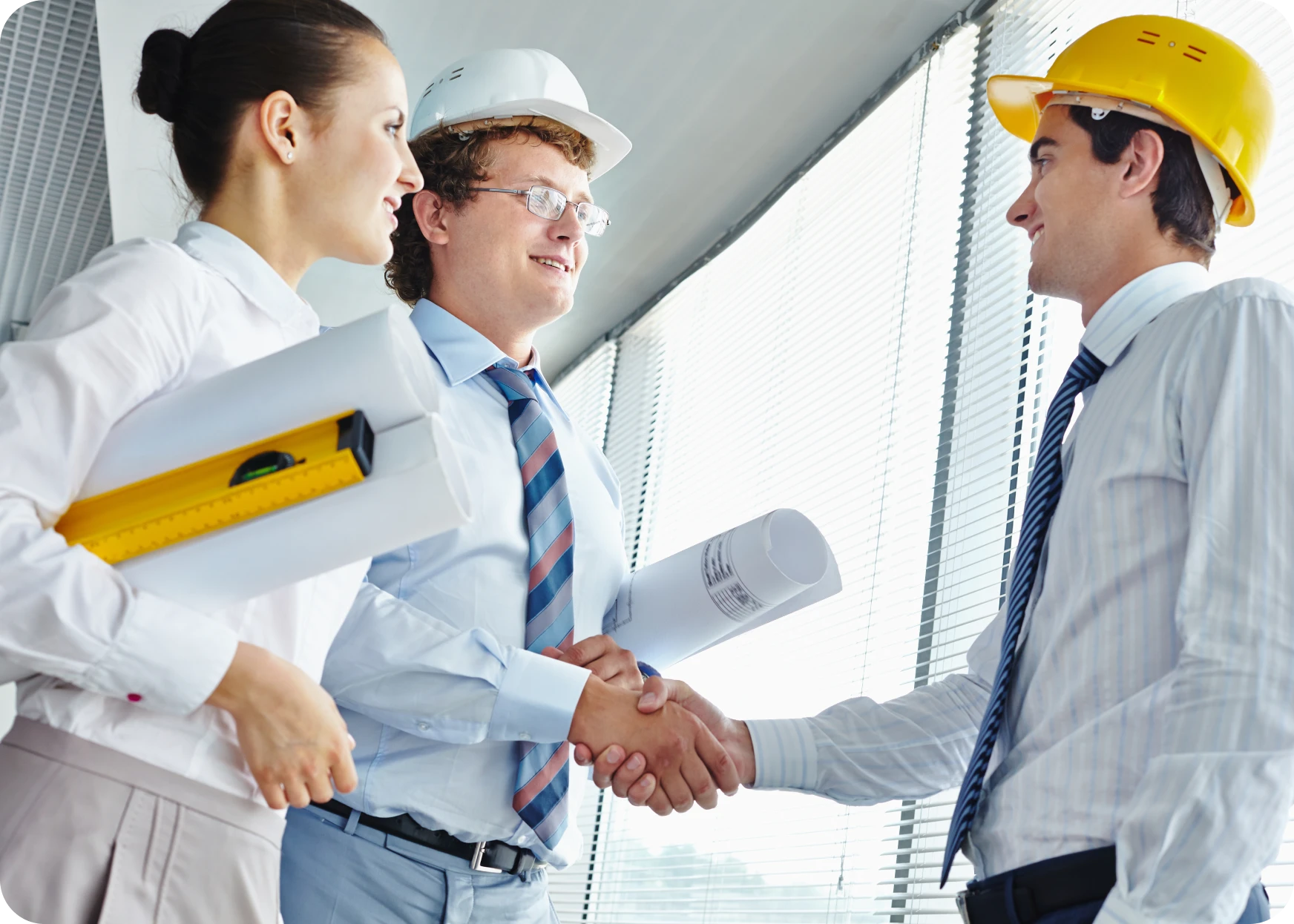 Contractors With Hard Hats Shaking Hands Indoors