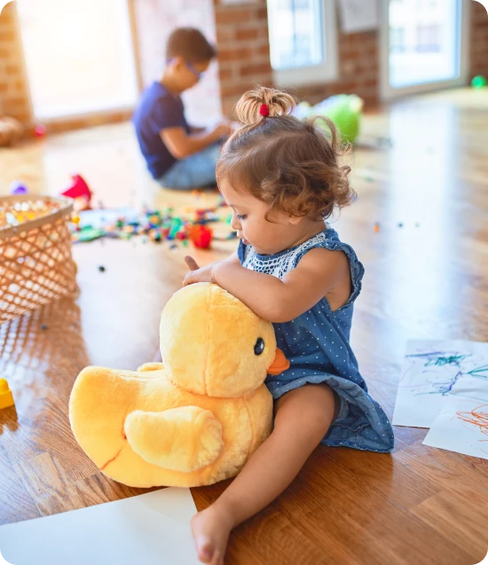 Child playing with stuffed duck in a safe and secure environment representing family insurance protection.