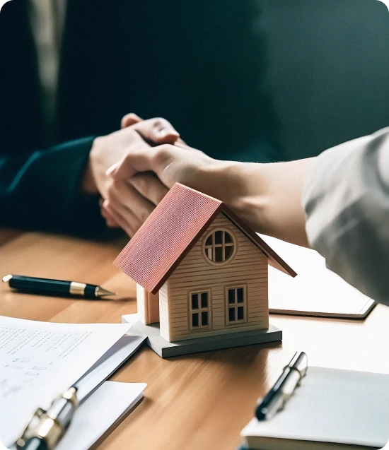 Two people shaking hands above house representing insurance agreement and property protection services.